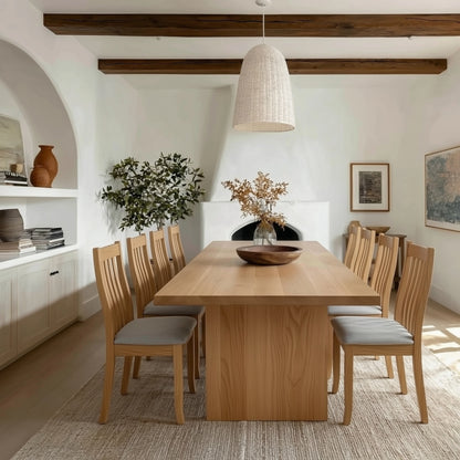 Dining room with wooden table and chairs, white walls, and decorative elements.