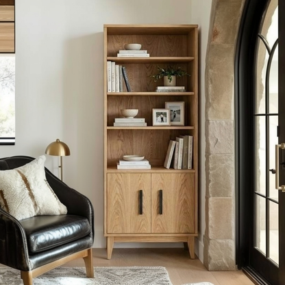 Wooden bookshelf with decorative items in a room with a black armchair and a lamp.
