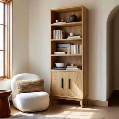 Wooden bookshelf with books and decor items next to a white armchair in a room with natural light.