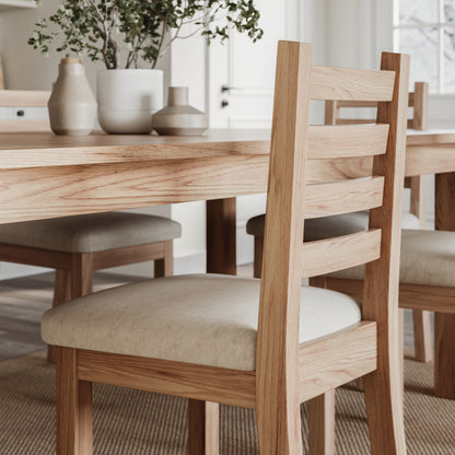 close up image of the side of an oak dining table with matching chairs
