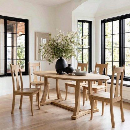 Dining room with wooden table and chairs, large windows, and decorative vase with flowers.