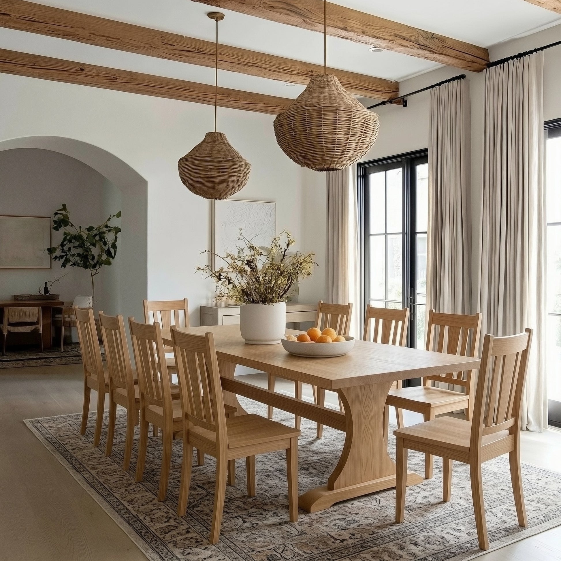 Dining room with wooden table and chairs, wicker pendant lights, and large windows.