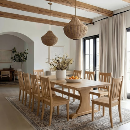 Dining room with wooden table and chairs, wicker pendant lights, and large windows.