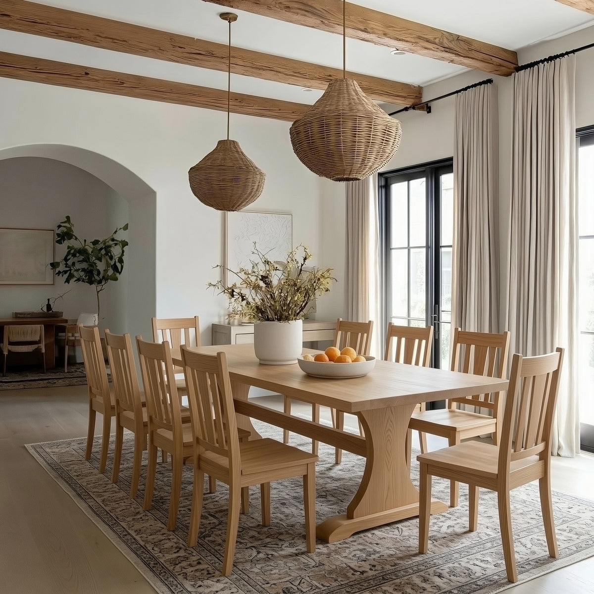 Dining room with wooden table and chairs, wicker pendant lights, and large windows.