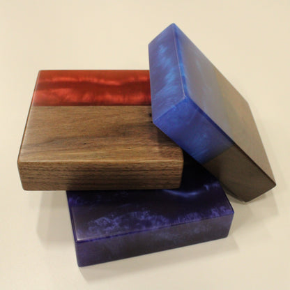 A set of three wooden blocks with epoxy samples in red, blue, and purple colors, displayed on a white background.