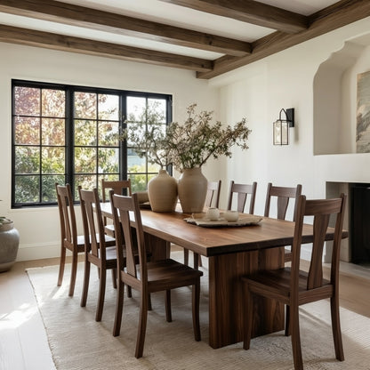 Dining room with wooden table and chairs, large window, and decorative elements.