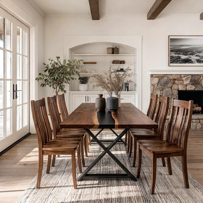 A wooden dining table with six matching slatted chairs, set on a textured rug in a bright, modern dining room with a fireplace, built-in shelves, and large glass doors.