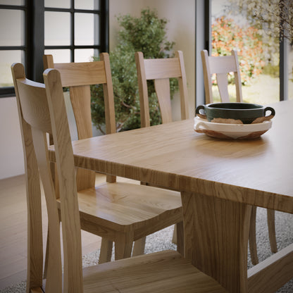 Wooden dining table with chairs in a bright room.