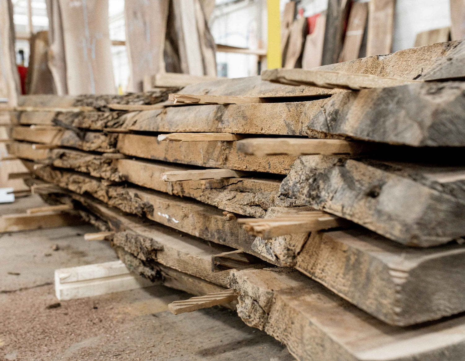 A stack of live edge wood slabs in a warehouse