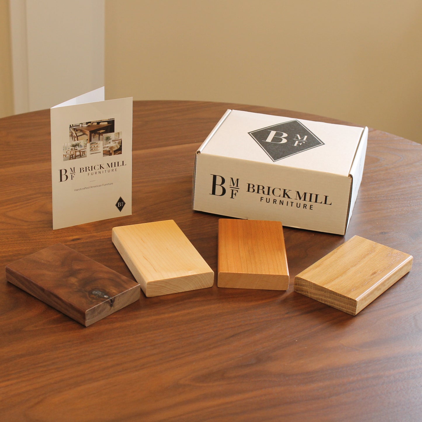 Wooden samples and a box with 'Brick Mill Furniture' branding on a wooden table.