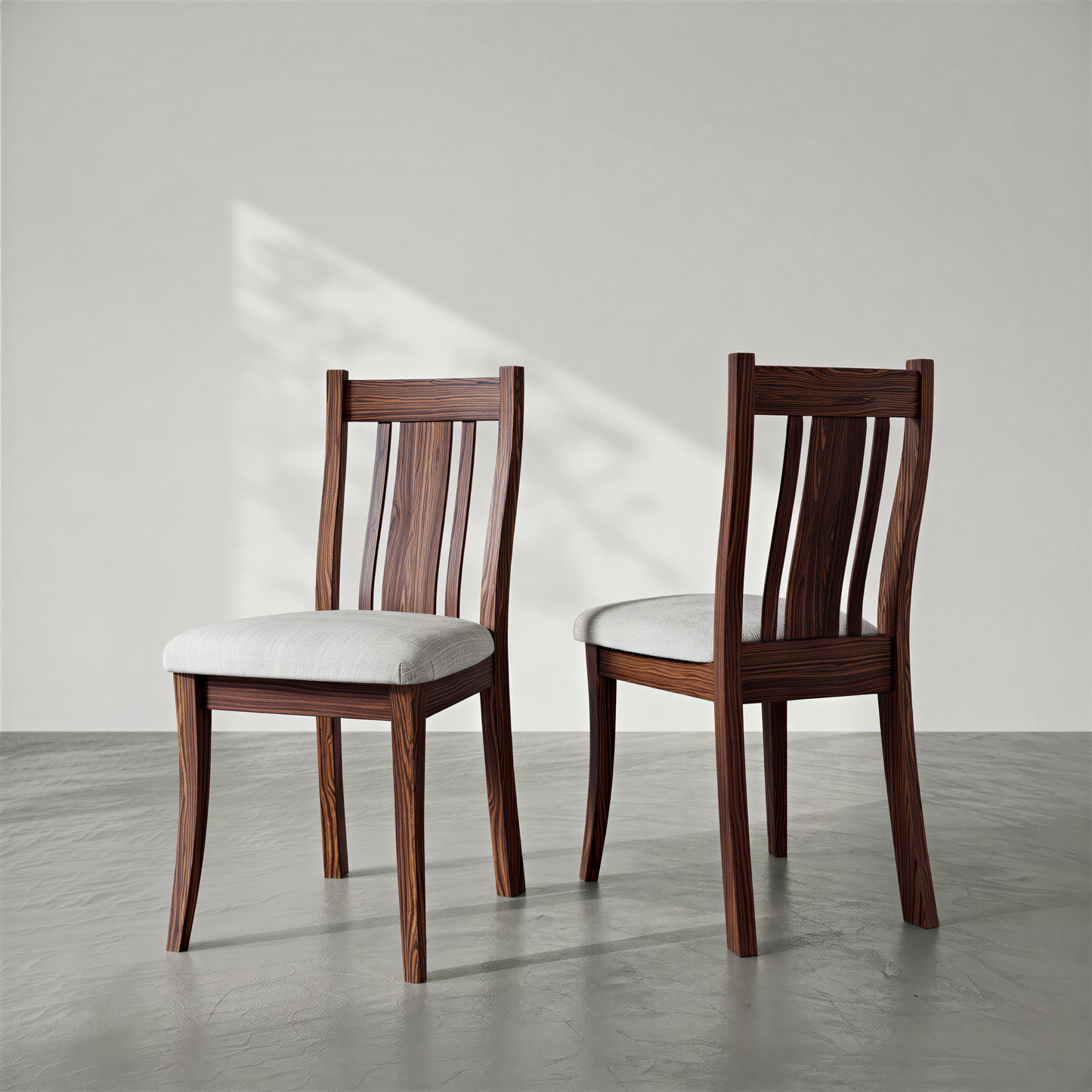 Two wooden chairs with white cushions on a gray floor and light gray background