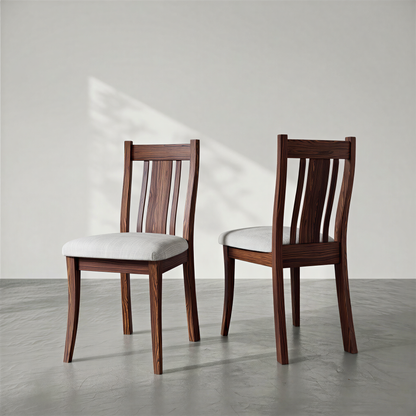 Two wooden chairs with white cushions on a gray floor and light gray background