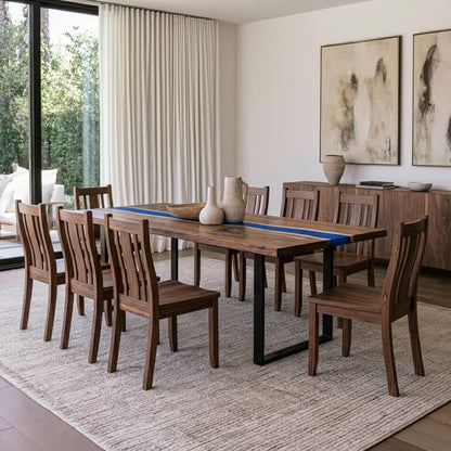 A rectangular wooden dining table with black metal legs and matching wooden slat-back chairs, styled in a bright, modern dining room with a blue runner, ceramic vases, and a sideboard.