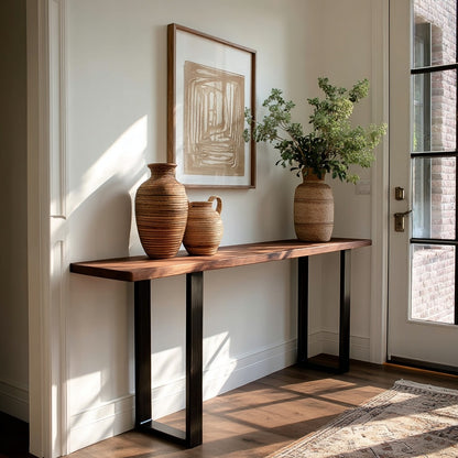 Wooden console table with decorative vases and a plant against a wall with a framed abstract painting.