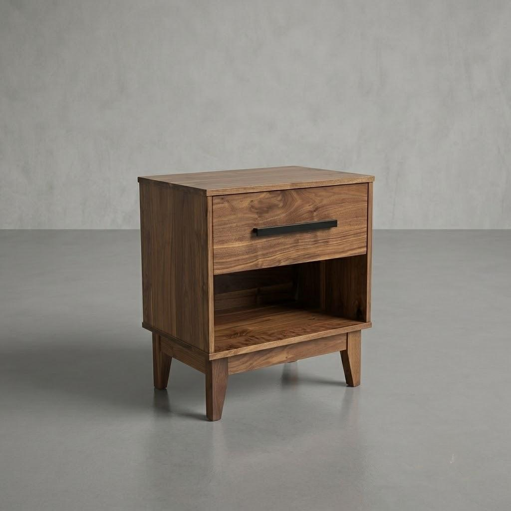 A mid-century modern Walnut Astoria Nightstand with a single drawer, open shelf, and tapered legs, shown on a gray concrete floor against a textured gray wall.