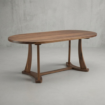 An oval wooden dining table with a medium brown wood grain finish, featuring curved legs and a central stretcher bar, set against a textured gray concrete wall and floor.