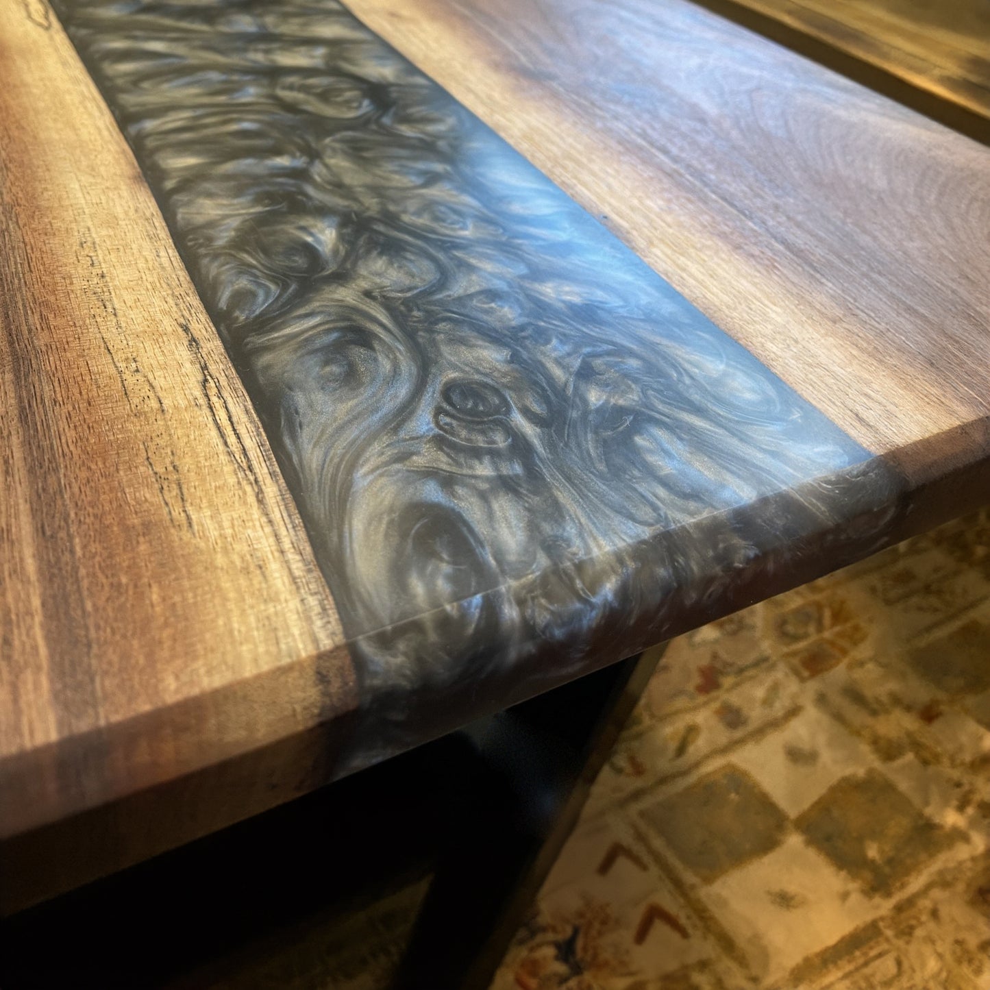 A walnut epoxy dining table with grey epoxy in a traditional living room setting