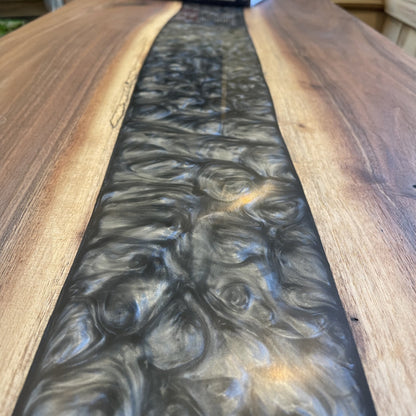A walnut epoxy dining table with grey epoxy in a traditional living room setting