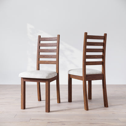 Two walnut wood Heisly dining chairs with a commercial grade finish and upholstered seats, displayed against a white background.
