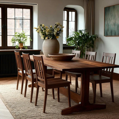 Dining room with wooden table and chairs, large vase with flowers, and plants.