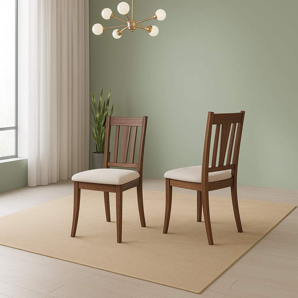 Two wooden chairs with beige cushions in a room with a green wall and a chandelier.