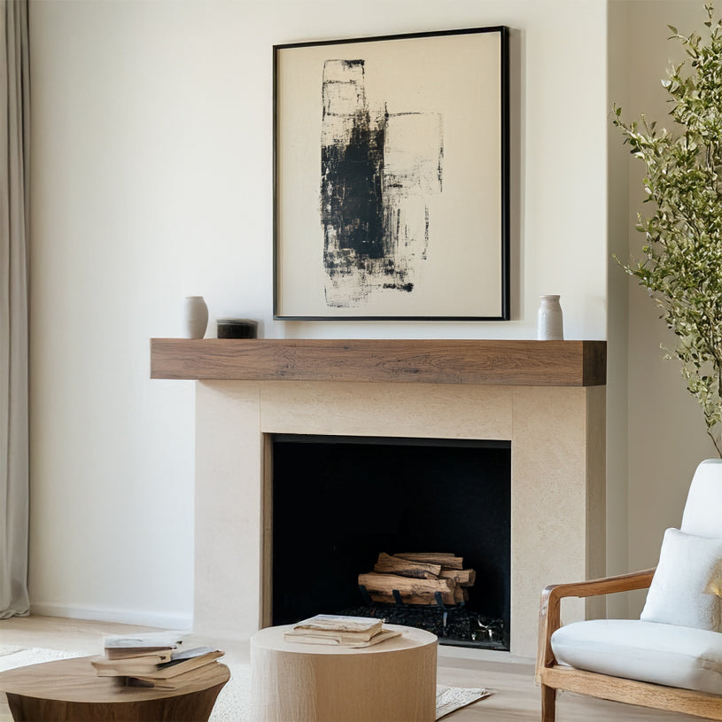 A plain walnut wood mantel shelf mounted on a white fireplace in a room with light decor.