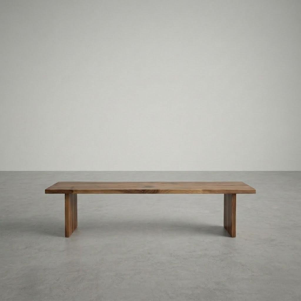 Wooden bench on a gray floor with a plain white wall background
