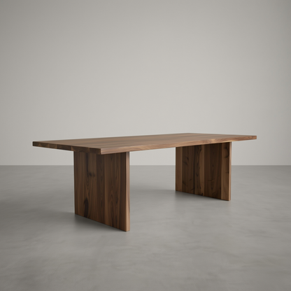A modern rectangular wooden dining table with a rich dark brown finish, featuring thick block-style legs and a live-edge tabletop, set against a minimalist gray concrete floor and background.