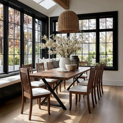 Dining room with wooden table and chairs, large windows, and decorative elements.