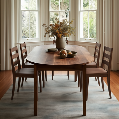 Dining room with wooden table and chairs, decorated with a vase and fruit bowl.