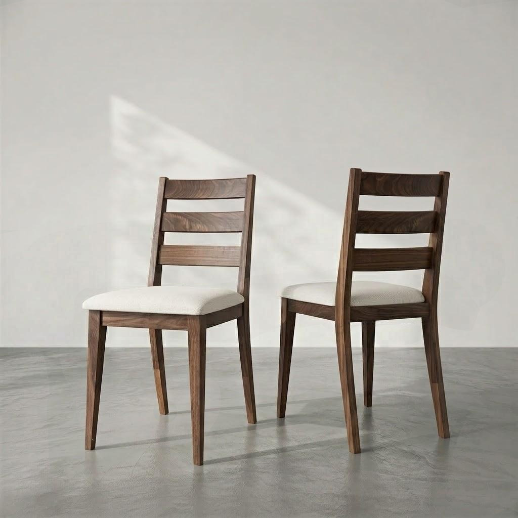 Two wooden dining chairs with cream upholstered seats, shown from the back in a minimalist studio setting with a gray floor and light gray wall.