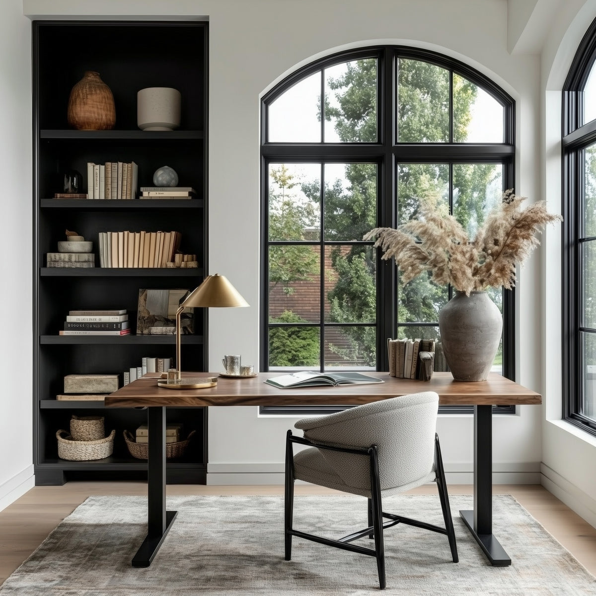 Home office with a walnut standing desk, bookshelf, and large window.