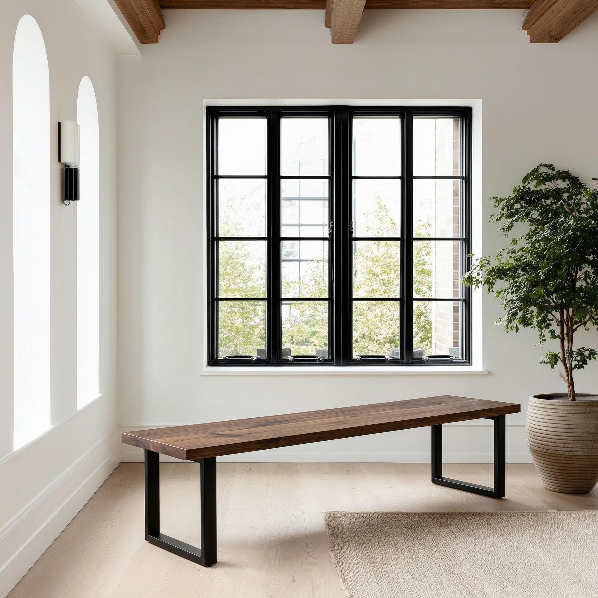 Modern room with a long wooden bench, large window, and potted plant.