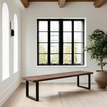 Modern room with a long wooden bench, large window, and potted plant.