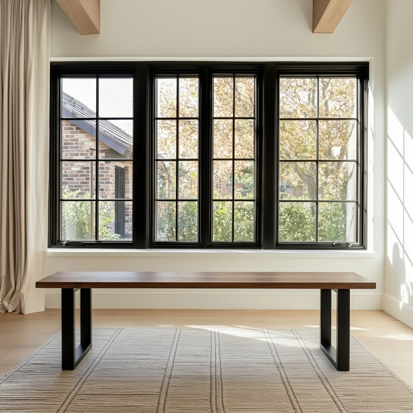 Modern interior with a wooden bench in front of large black-framed windows.