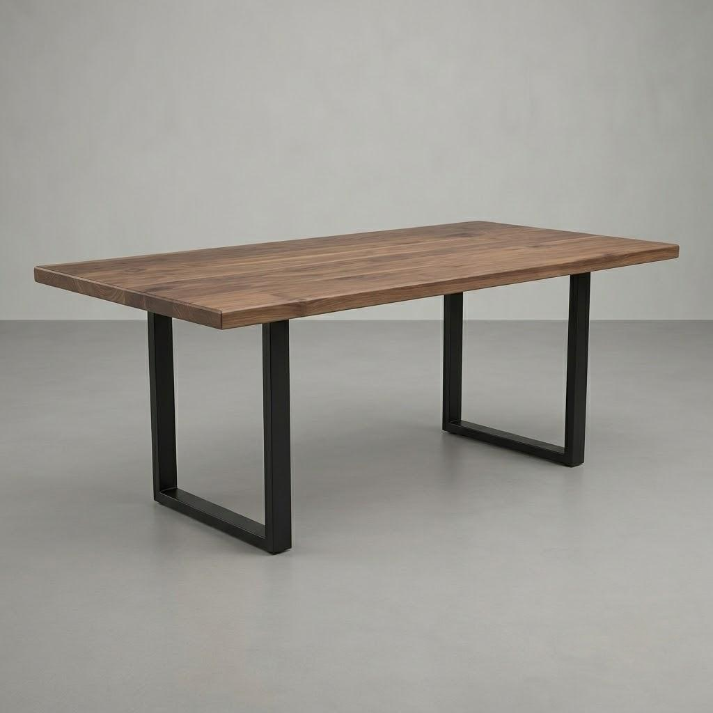 A rectangular wooden dining table with a medium brown wood grain top and black metal U-shaped legs, shown on a light gray studio floor against a gray wall.