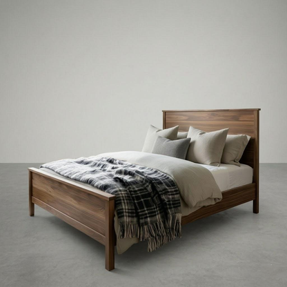 Wooden bed with bedding and a plaid blanket on a plain background