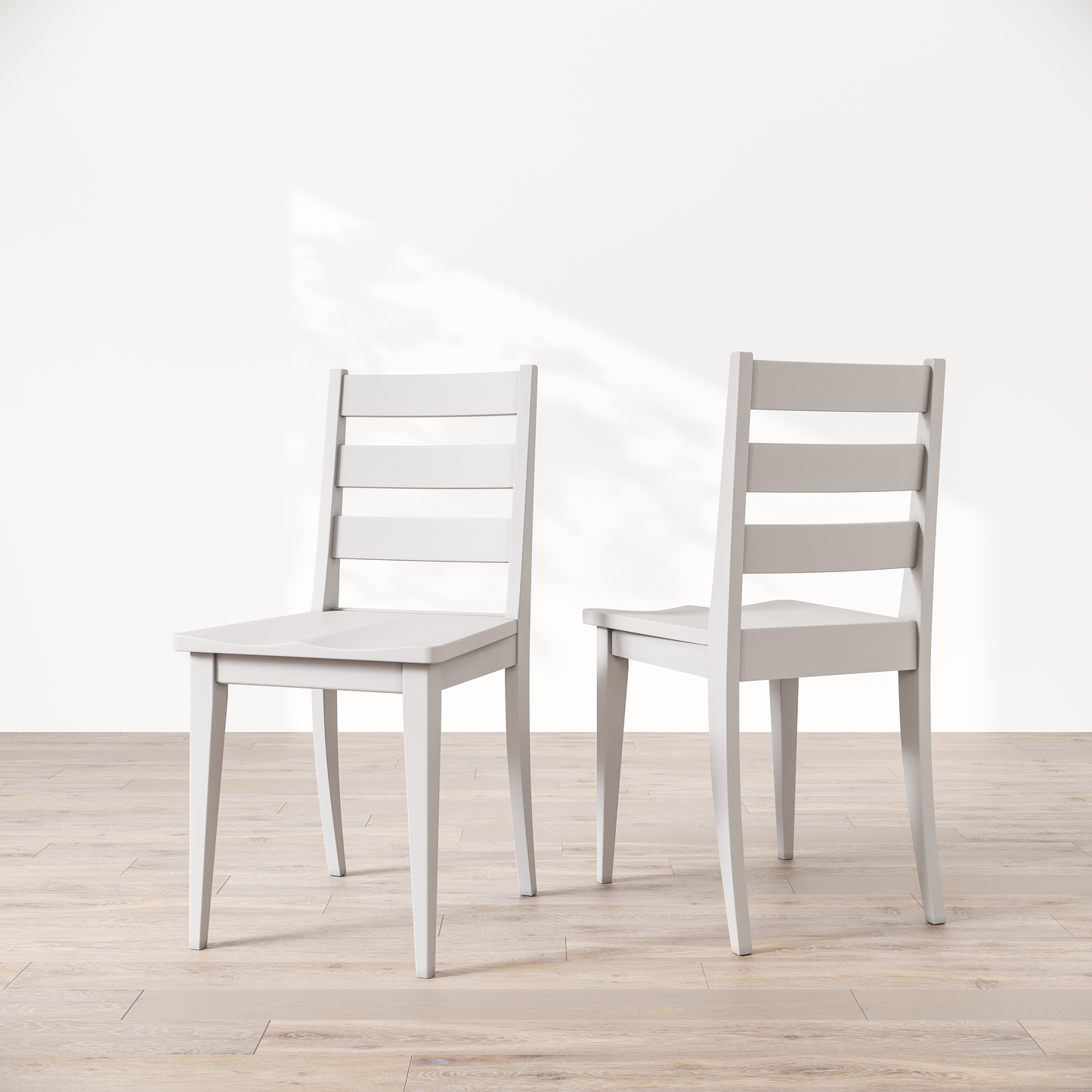 Two white wooden dining chairs featuring a simple, solid backrest and seat design on a light background.