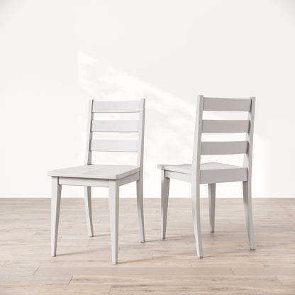 Two white wooden dining chairs featuring a simple, solid backrest and seat design on a light background.